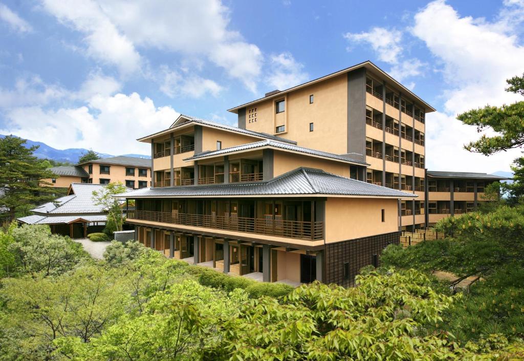 Midrise ryokan building surrounded by forest Tokinoniwa Gunma Multi-story ryokan exterior with balconies and greenery at Tokinoniwa in Gunma, Kantō