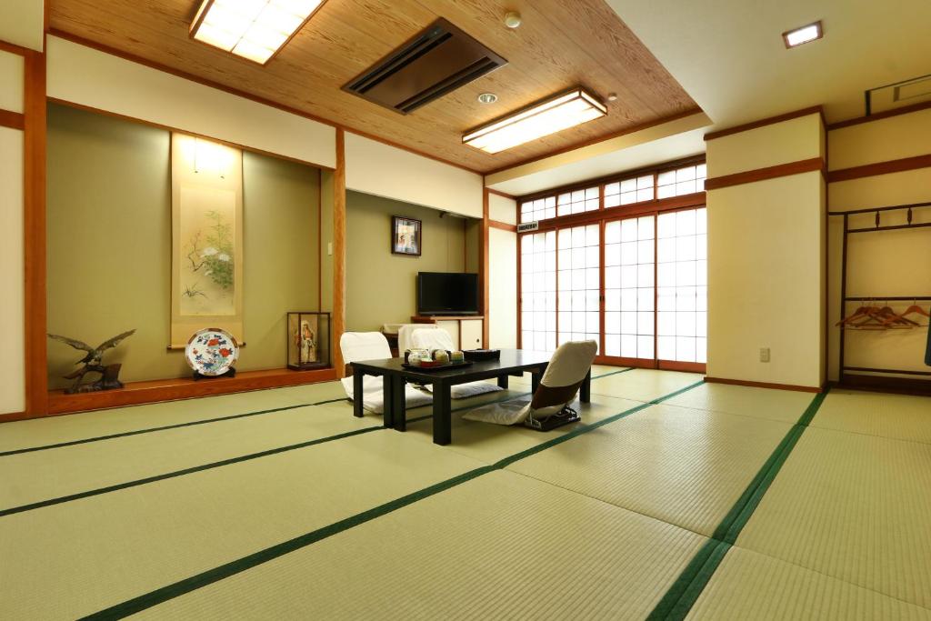 Tatami Room at Toyofuku Ryokan Hyōgo Traditional tatami room with low table, floor chairs, shoji screens and tokonoma at Toyofuku Ryokan in Hyōgo