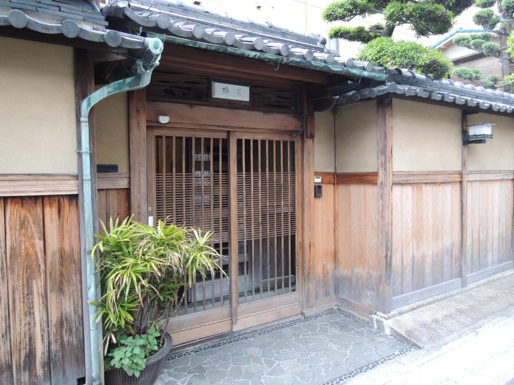 Wooden Ryokan Entrance at Tsubakiso Nara Traditional wooden entrance with sliding lattice door, potted plants and stone path at Tsubakiso, Nara, Kansai