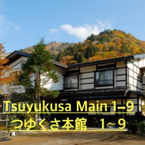 Exterior of Tsuyukusa ryokan beside tree-covered hillside with autumn foliage in Gifu Chūbu