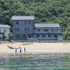 Beachfront Uminone building with kayaks and visitors on shore, Hyōgo, Japan