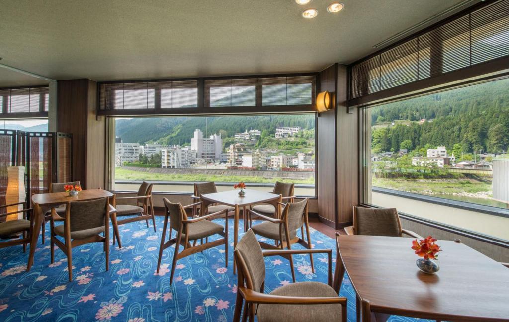Riverside lounge at Yamagataya Gifu Seating area with tables and panoramic windows overlooking river and town at Yamagataya in Gifu, Chūbu region