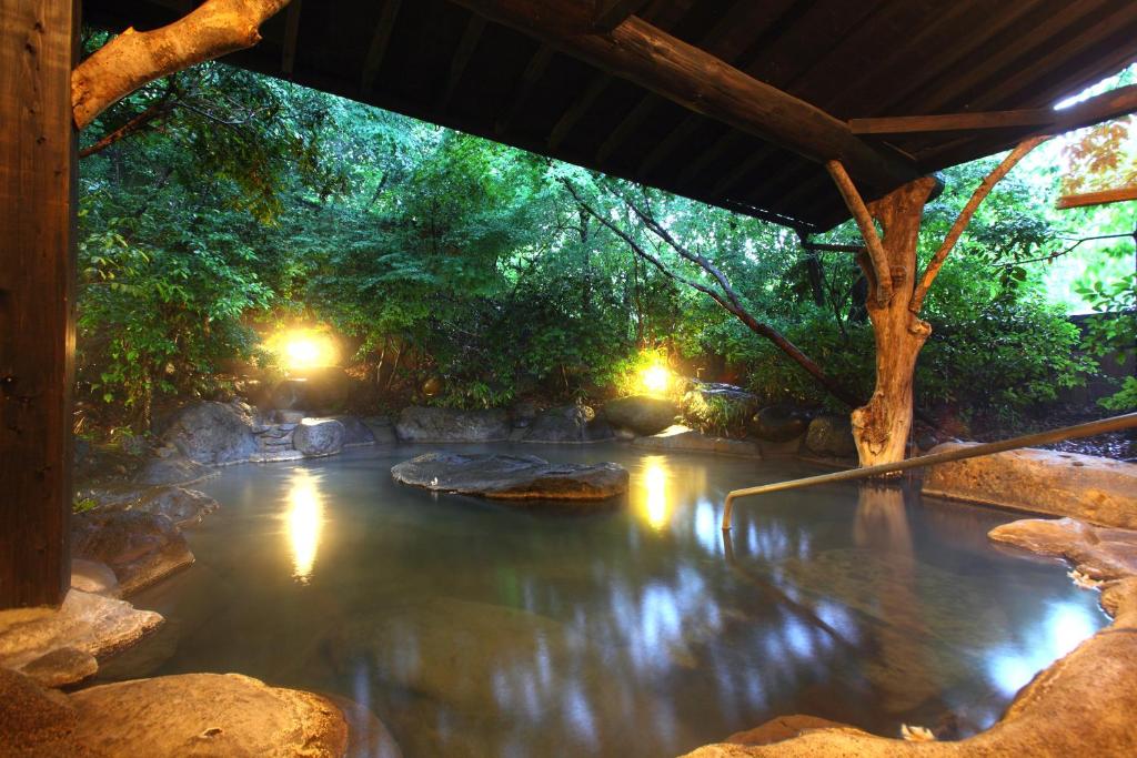 Covered garden onsen Yamashinobu Kumamoto Covered rock onsen pool surrounded by trees at Yamashinobu in Kumamoto, Kyūshū