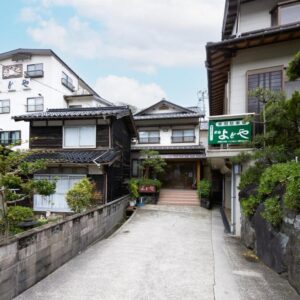 Entrance walkway and facade of Yodoya ryokan in Hyōgo, Kansai with stone walls and greenery