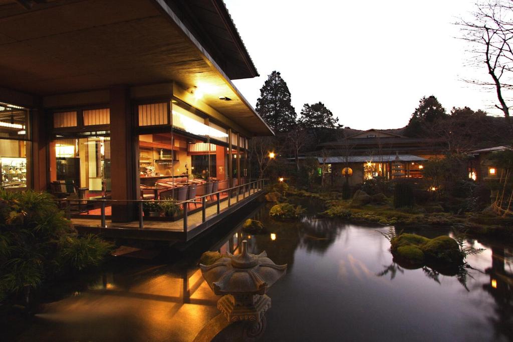 Ryokan garden at dusk Yoshimatsu Kanagawa Lit wooden veranda overlooking reflecting pond and stone lanterns in a garden at dusk, Yoshimatsu Kanagawa