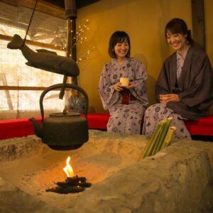 Two guests in yukata at irori hearth with kettle, Yumerindo, Kumamoto, Kyūshū