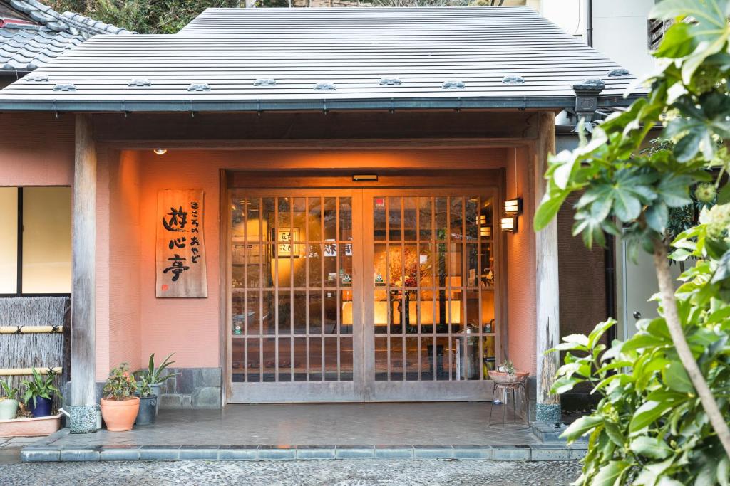 Ryokan entrance at Yushintei in Kanagawa Traditional wooden entrance with lattice doors, potted plants and kanji sign at Yushintei ryokan in Kanagawa