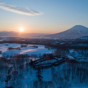Aerial view of snow-covered Zaborin grounds with distant mountain and sunrise in Hokkaidō