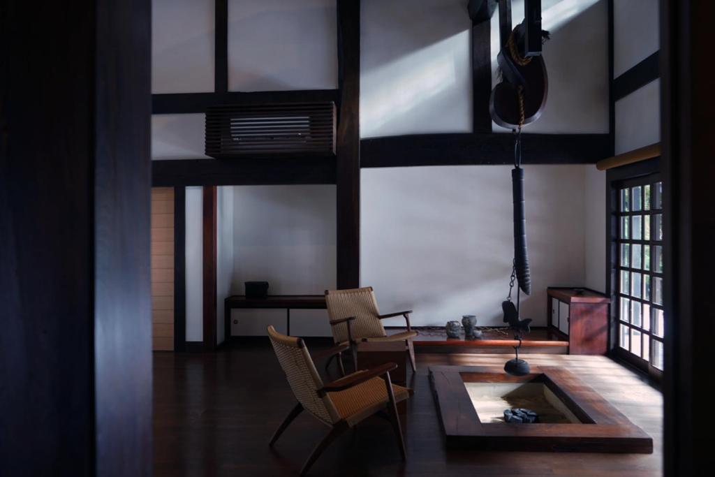 Sunlit irori seating at kutokuan Gifu Low wooden irori hearth and chairs inside kutokuan, Gifu, Chūbu, Japan