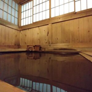 Indoor wooden onsen bath with shoji windows at Hirayunomori Bettei Yuuka Sanzōan, Gifu
