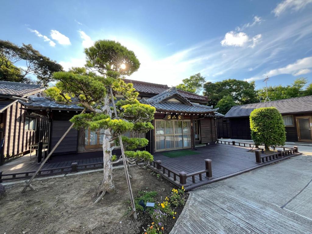 Ryokan exterior with garden Ichishuku Chiba Wooden ryokan exterior with sculpted tree and veranda at Ichishuku Ikkei Isshōen, Ichihara Chiba