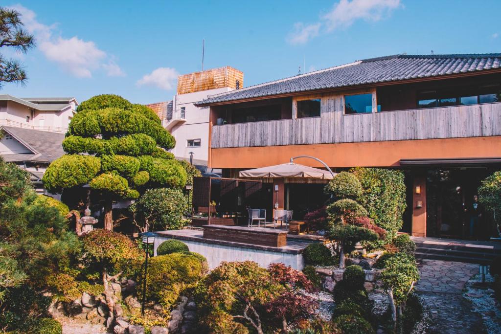 Tranquil garden courtyard Waseidō Zen Hyōgo Traditional ryokan exterior with manicured Japanese garden, stone path and seating at Waseidō Zen in Hyōgo