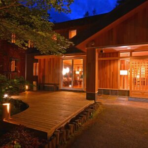 Warmly lit wooden entrance and deck at Yunomori, Okunikko Yumoto Onsen in Tochigi at dusk