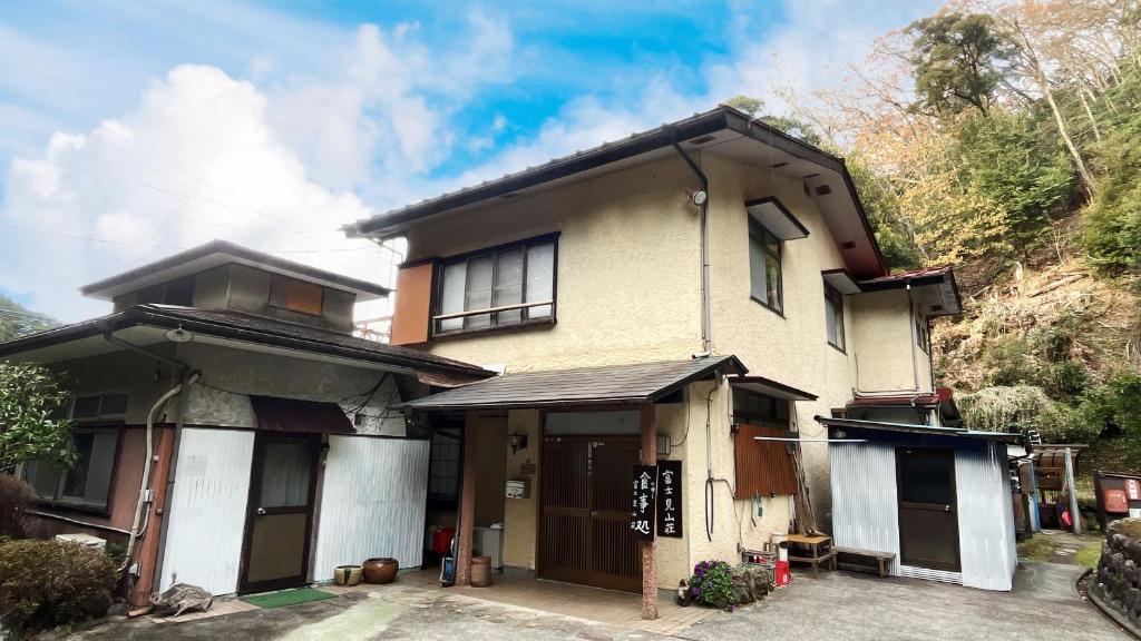 Traditional ryokan exterior Fujimi Sansō Shizuoka Two-story ryokan exterior at Fujimi Sansō with entrance and potted plants Shizuoka Chūbu