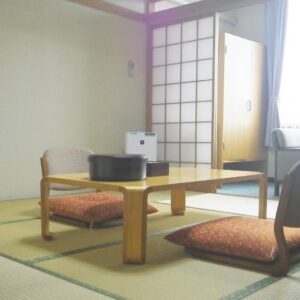 Tatami room with low table, zaisu chairs and shoji screens at Nunobiki Onsen Komoro, Nagano