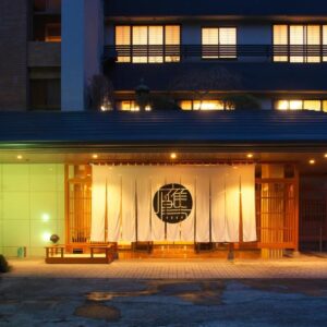Entrance with noren, wooden doorway and warm exterior lighting at Oyado Zuiyō, Shizuoka, Chūbu, Japan