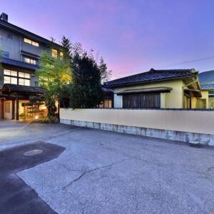Twilight exterior showing Tamano-yu entrance and sign at Togura Kamiyamada Onsen Nagano