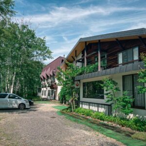 Gravel driveway and birch trees leading to Sansō Watari auberge thermale building in Nagano