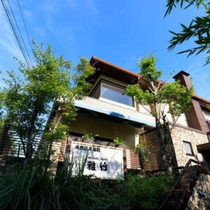 Stone exterior and wooden roof with Miyabitake sign, lush greenery, Kanagawa, Kantō, Japan
